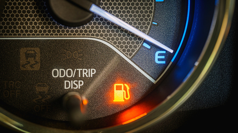Low fuel light showing on a car's dashboard