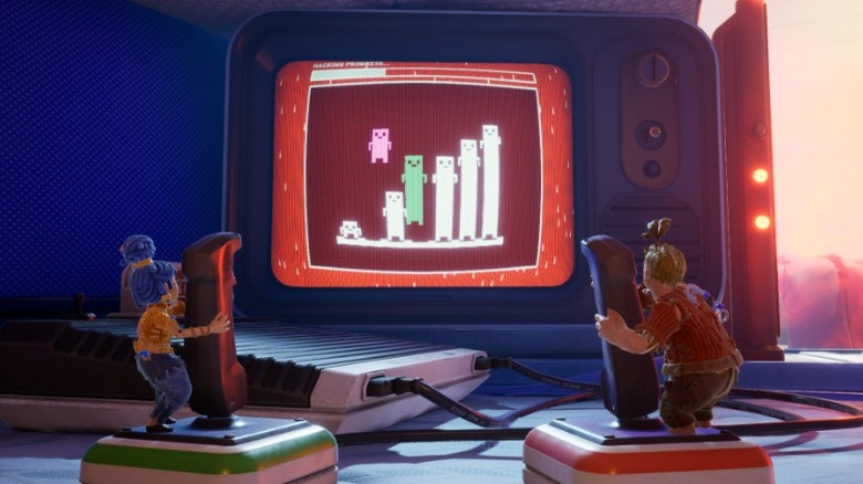Two dolls cooperating to complete a video game together.