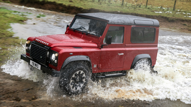 Land Rover Defender Works V8 driving through a river