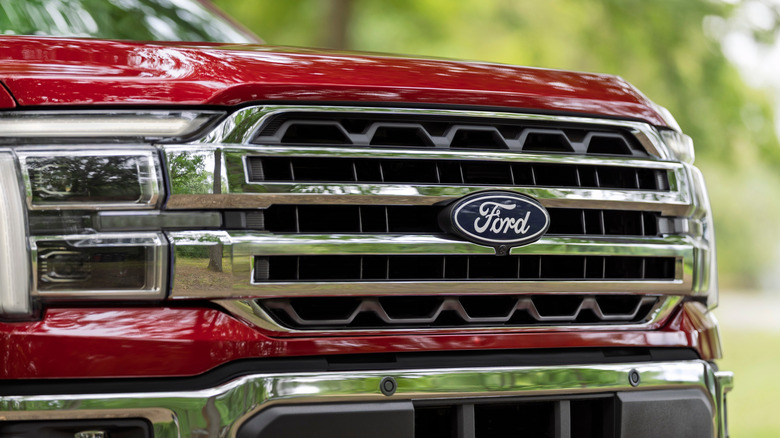 Close-up shot of a red 2027 Ford F-150 Lariat's front fascia