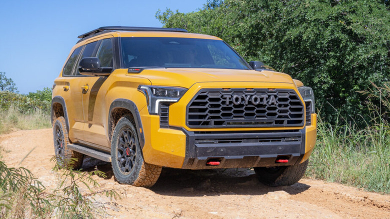a yellow 2027 Toyota Sequoia TRD Pro driving on a dirt road