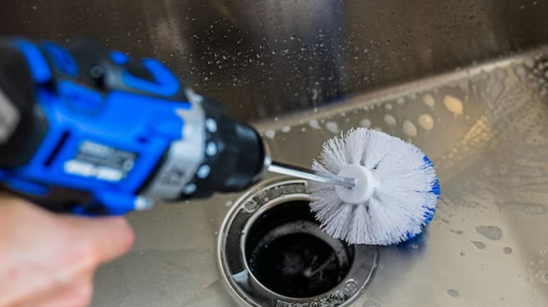 A person using a Rotoscrub brush in a sink.