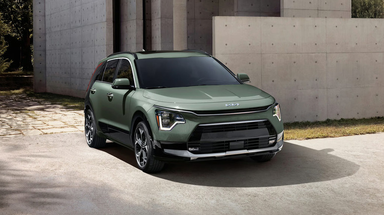 A 2026 Kia Niro Hybrid Electric Vehicle (HEV) standing parked next to a curb in a residential neighborhood.