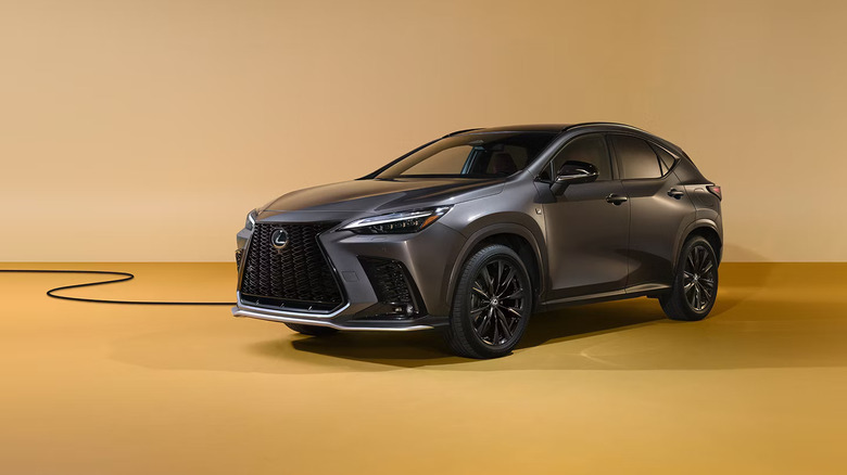 A gray 2026 Lexus NX 350h hybrid SUV standing against a two-tone pastel yellow background, with a wire visible.