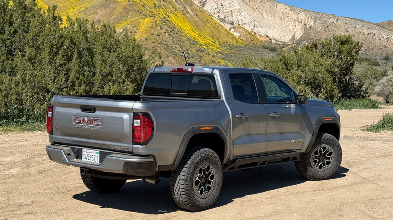 2026 GMC Canyon AT4X parked in front of a mountain superbloom