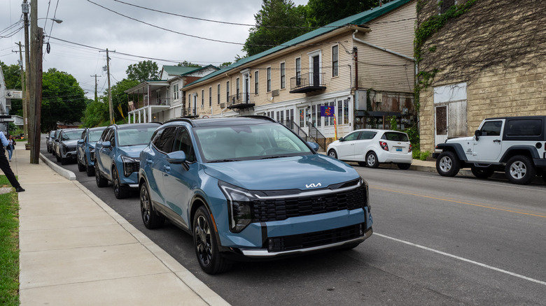 A row of 2026 Kia Sportage HEVs parked along a street