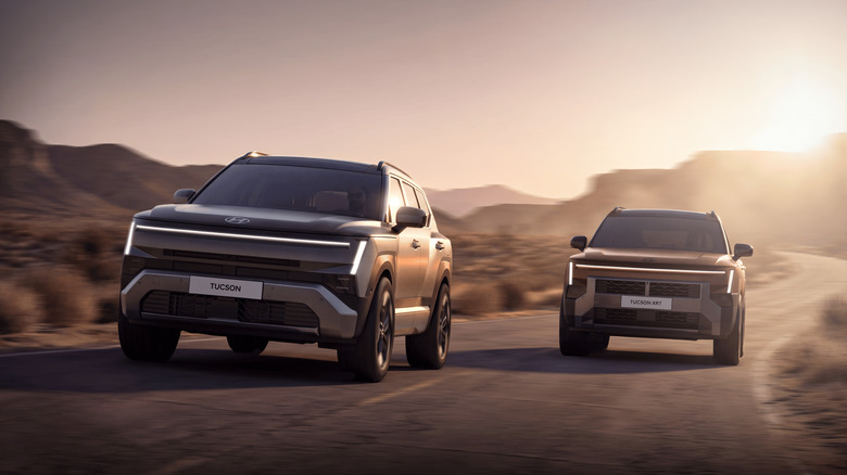 Two 2027 Hyundai Tuscon models driving side by side down desert road, front-on view