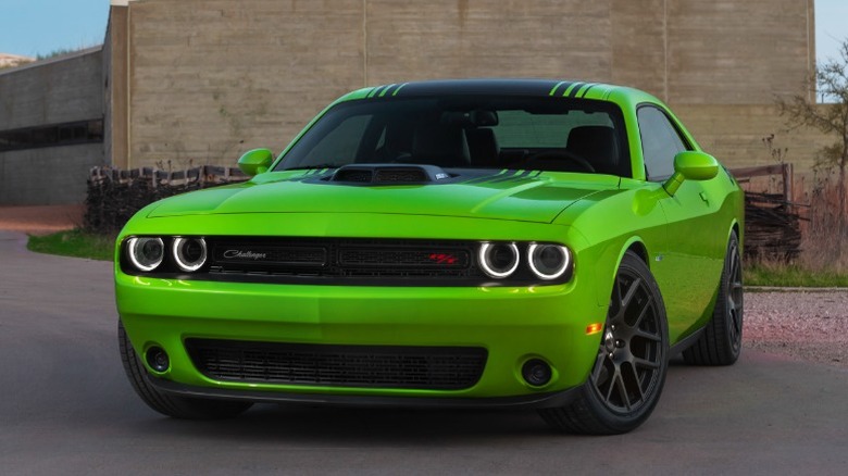 Black and green Dodge Challenger R/T Plus Shaker parked in front of a minimalist building