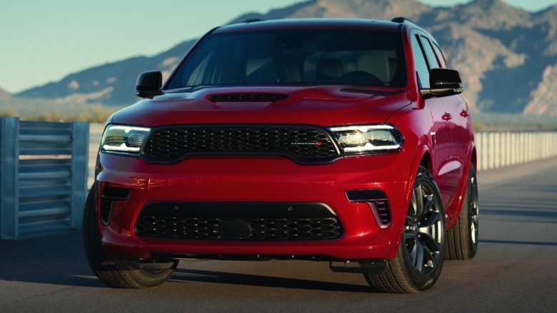 Red Dodge Durango R/T parked next to a barrier with mountains in the distance