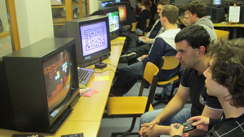 People playing retro game consoles on CRT televisions in 2012