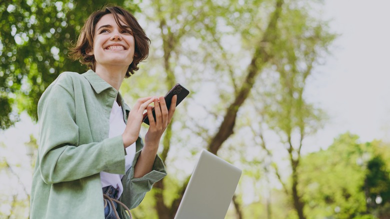 Woman with phone and laptop