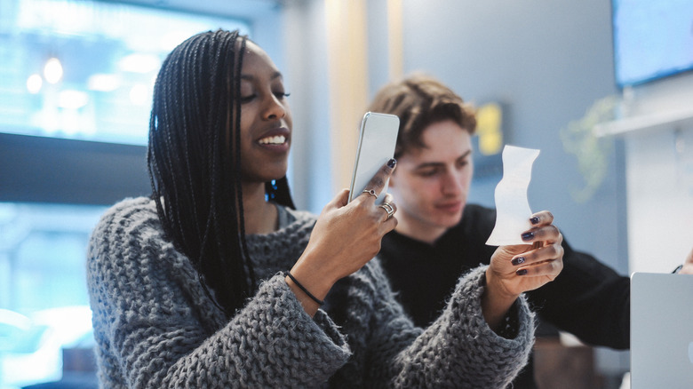 woman scanning receipt with phone