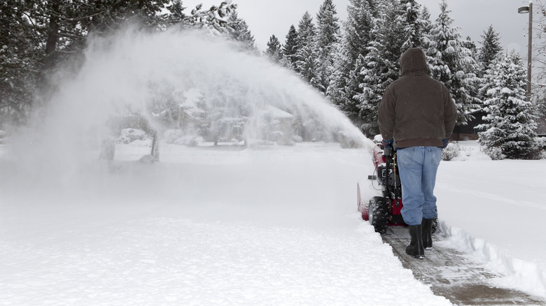 person using electric snow shovel to clear a path