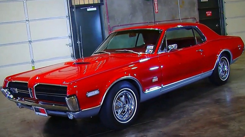A red 1968 Mercury Cougar GT-E hardtop with wide whitewall tires.