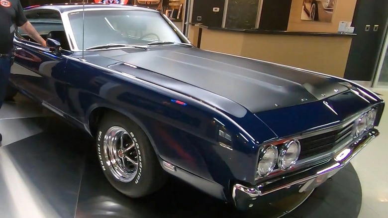 Deep navy blue 1969 Ford Torino Talladega on turntable inside showroom.