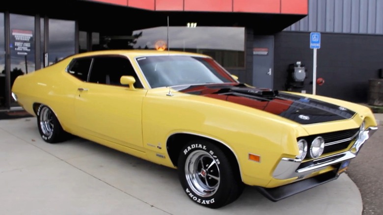 A bright yellow 1970 Ford Torino Cobra with a blacked-out hood scoop.