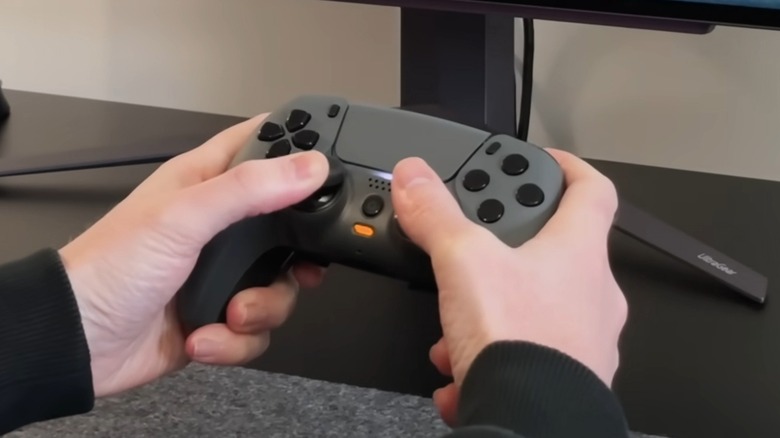 A person holding a Scuf Gaming PS5 controller.