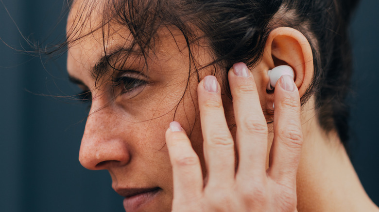 Person touching earbud