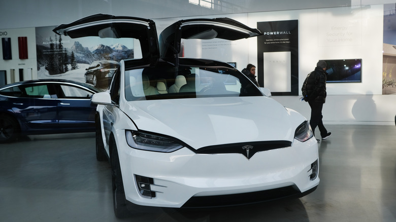 A white Tesla at a dealership.