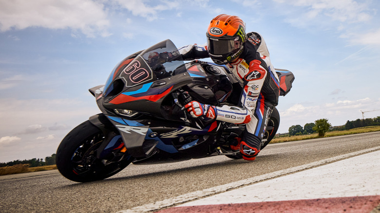Close up view of a 2023 BMW M 1000 RR cruising through a sharp turn in a closed track