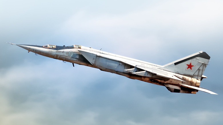 A Russian Air Force MiG-25RBS climbing over cloudy skies