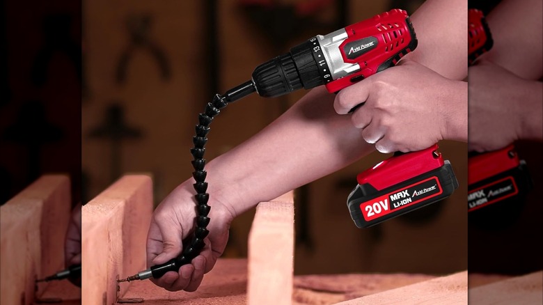 A person using the Avid Power cordless drill with a flexible extension.