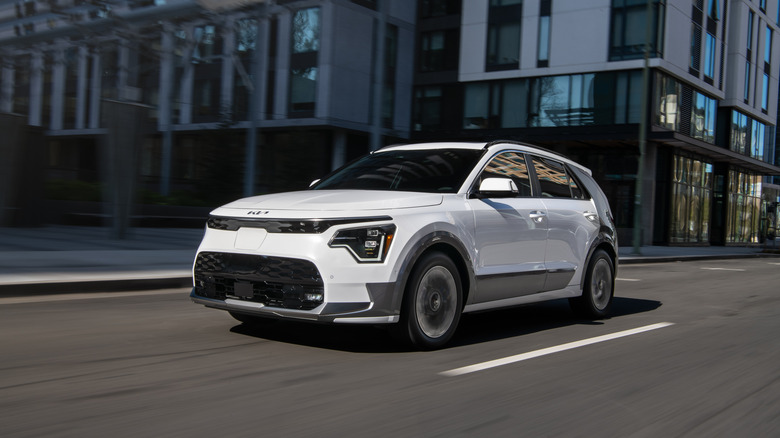 A white 2026 Kia Niro EV driving in an urban environment