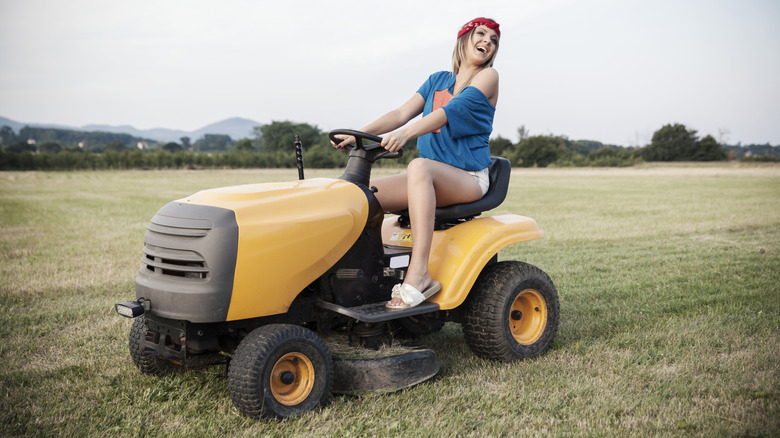 woman riding lawn mower