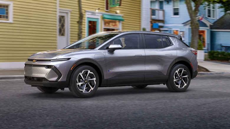 The 2026 Chevrolet Equinox EV 1LT shown on the road in front of a yellow building
