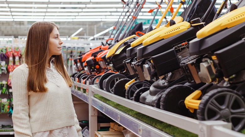 person in store browsing lawn mowers