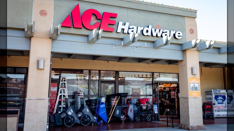 Ace Hardware store front with wheel barrows and ladders on display.