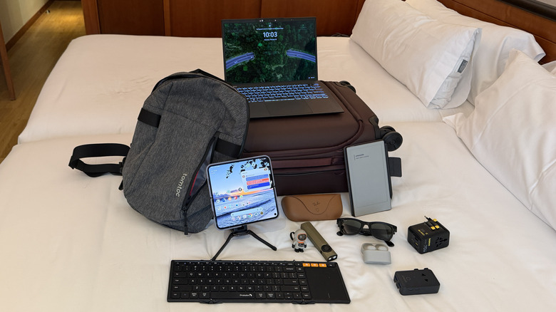 Multiple tech items on a bed.