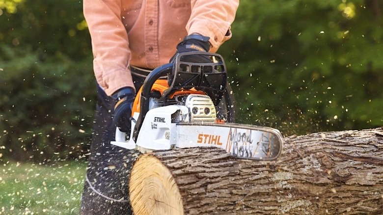 Person cutting wood with a Stihl chainsaw