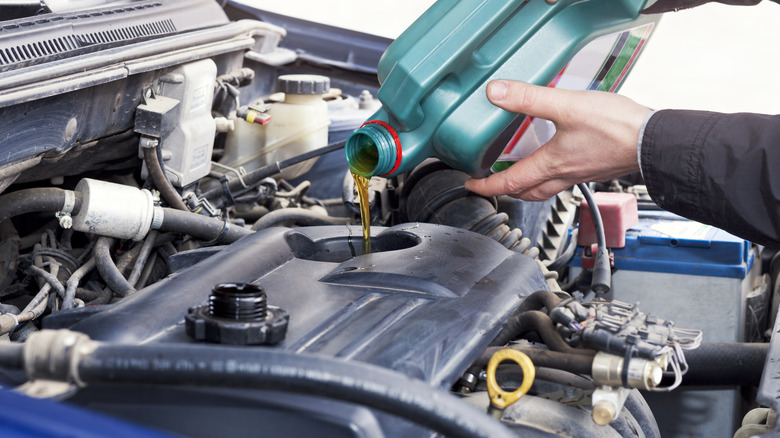 Pouring engine oil into engine