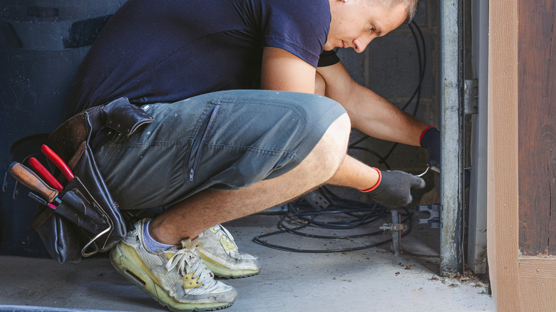 Man repairing garage door sensors