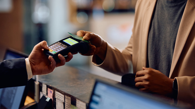 Close up of African American man using credit card while paying in a hotel