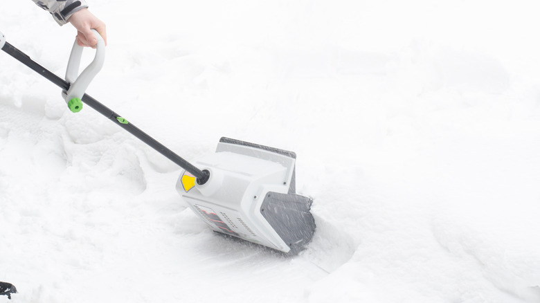 person using electric snow shovel
