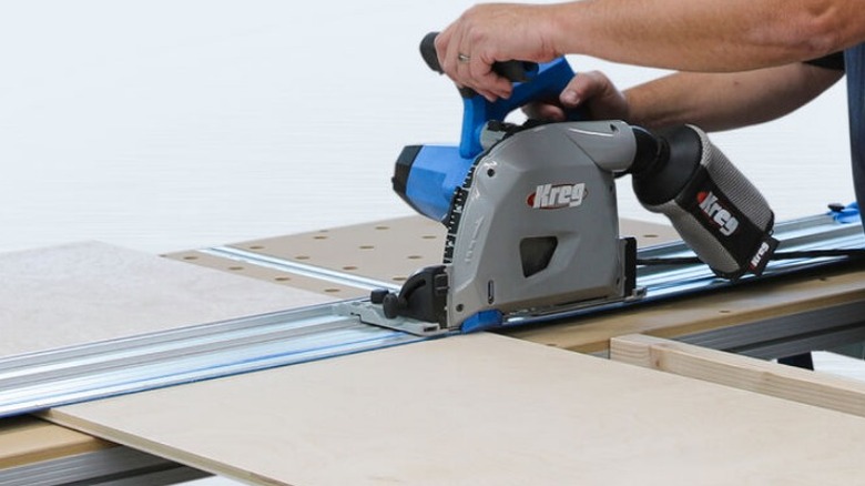 Person cutting plywood with Kreg track saw