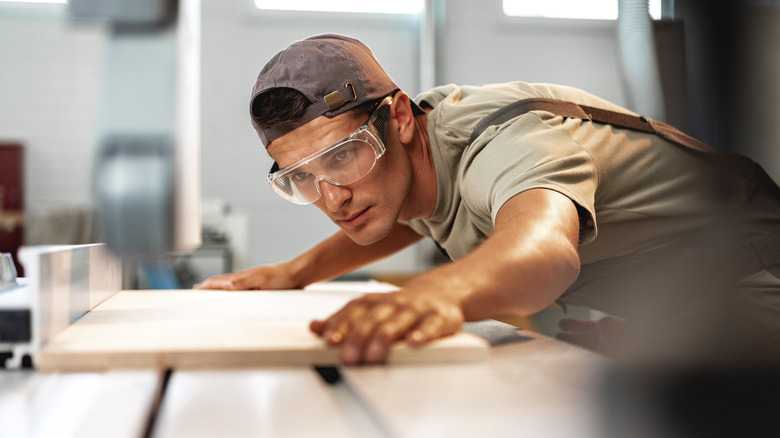 Person cutting plywood on tablesaw