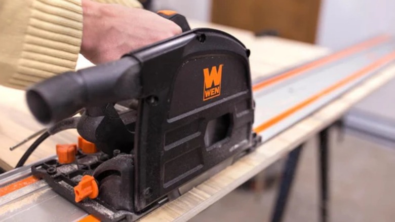 Person cutting plywood with Wen track saw