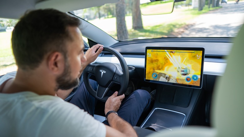 Man playing racing game in Tesla