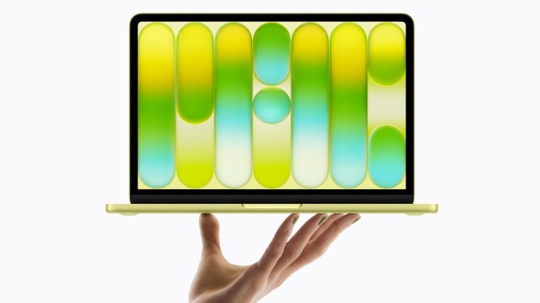 A hand lifting a MacBook Neo