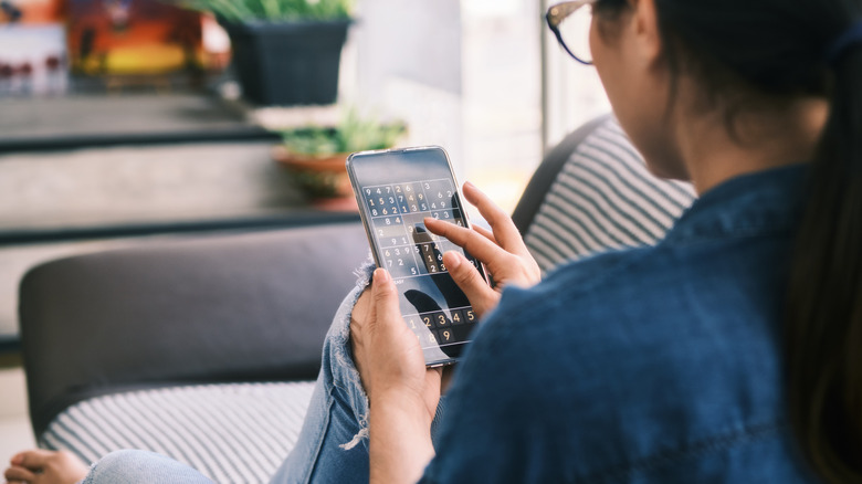 Woman playing Sudoku on phone