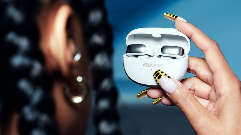Person holding the Bose Ultra Open earbuds
