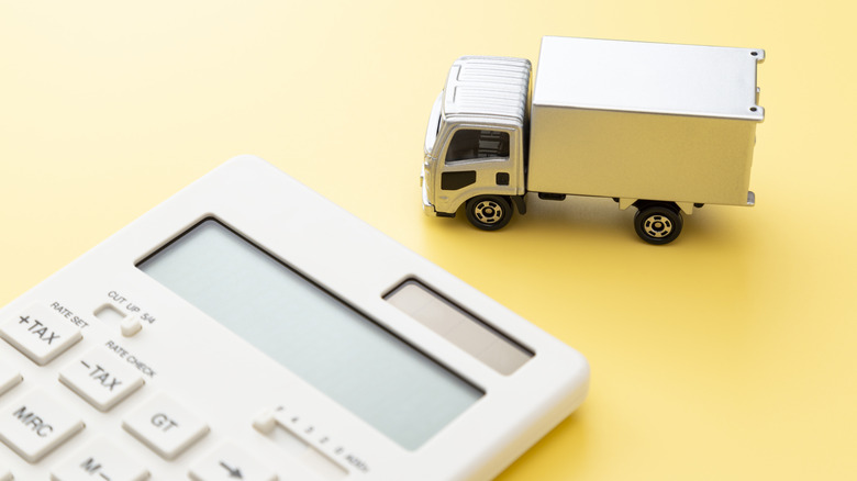 Delivery truck toy next to calculator