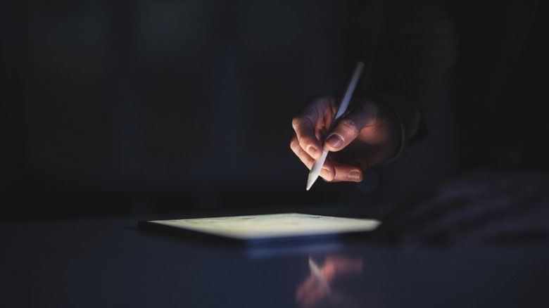 Person using an iPad with a stylus