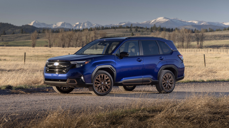 2025 Subaru Forester in blue with gold wheels, front 3/4 view