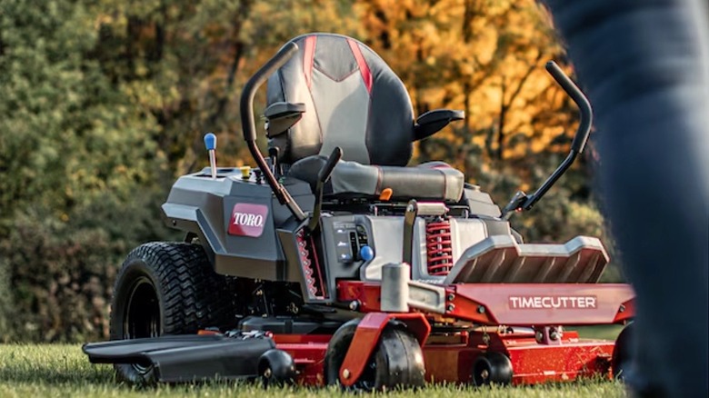 Person walking towards Toro mower in a yard