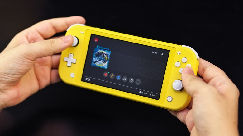 Two hands holding a yellow Nintendo Switch Lite