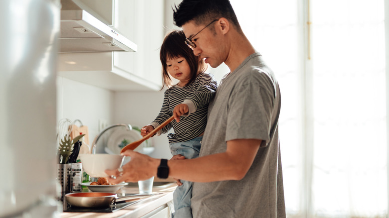 Adult and child cooking together
